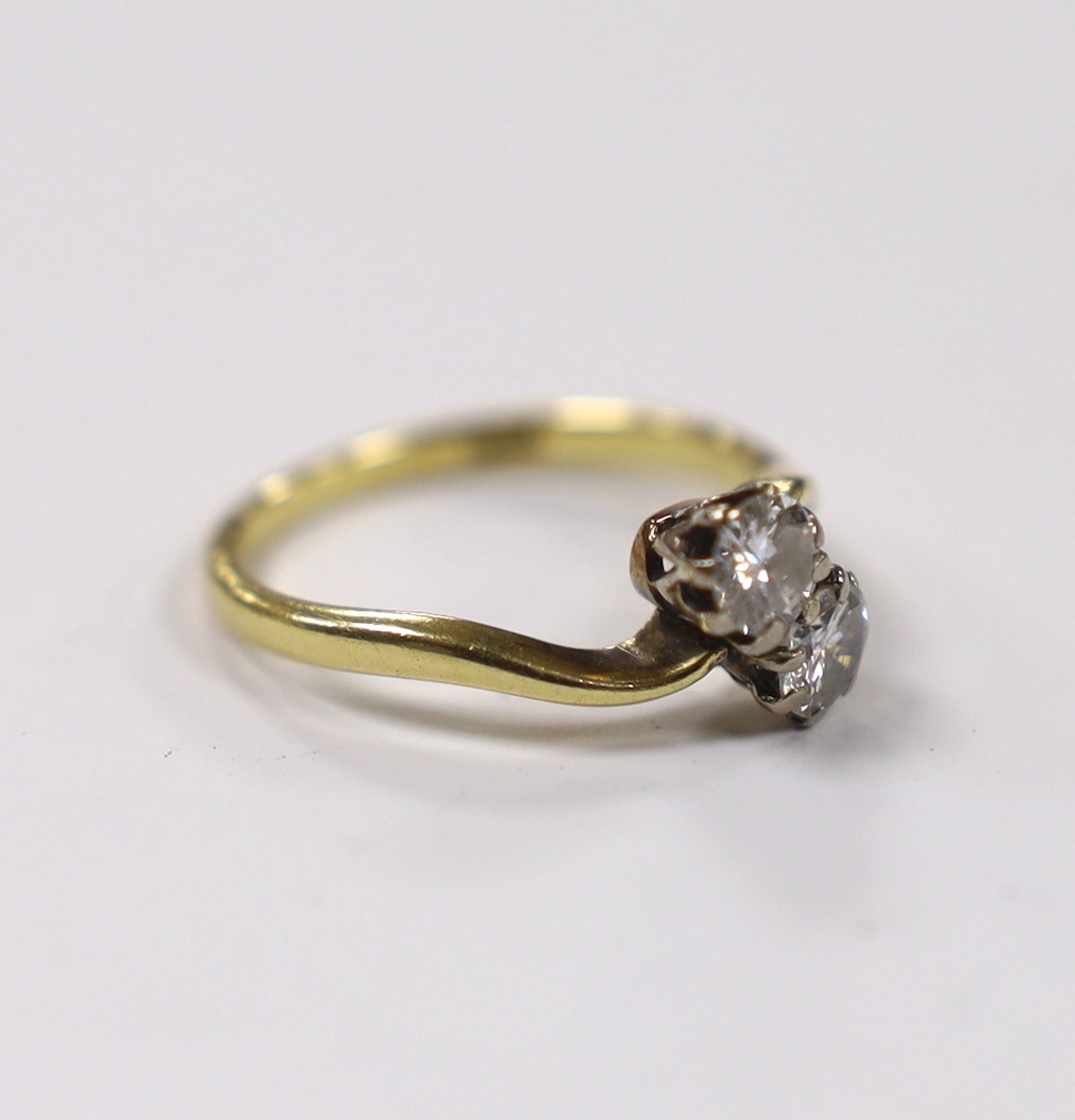An 18ct and two stone diamond set crossover ring, size M, gross weight 2.8 grams